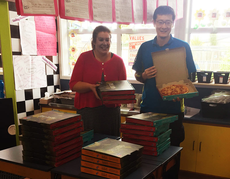 Leo Lee presents the pizza prize to teacher Angela Jones at South Hornby School.