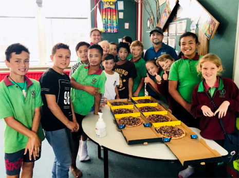 Smithesh Thomas hands out pizza to youngsters at Somerset Crescent School, Palmerston North.