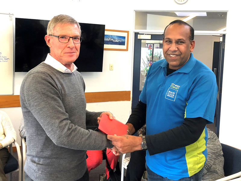 Brian Bayly, Macleans Primary School principal, presents a card and gift voucher to CrestClean’s Kamal Jeet Singh.