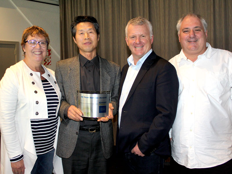 Martin Kim receives his 15-year long service award from CrestClean managing director Grant McLauchlan. Looking on are Caroline Wedding, Auckland West regional manager, and Dries Mangnus, Auckland Central regional manager.