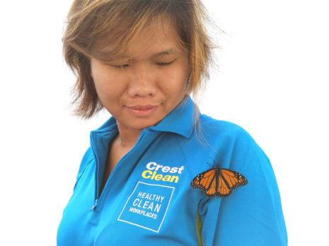 Zar San enjoys the moment as a monarch butterfly briefly rests on her CrestClean uniform.