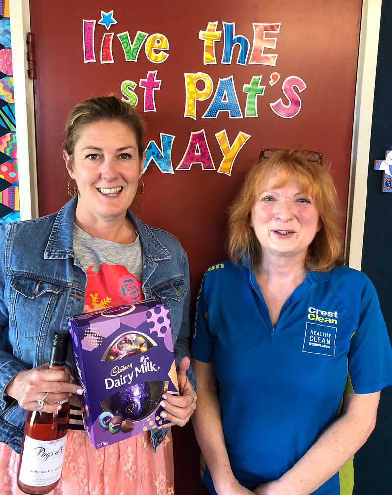 Teacher Kaehlah Dawson is delighted to receive a surprise gift of choclotes and wine from CrestClean business owner Deborah Herries.