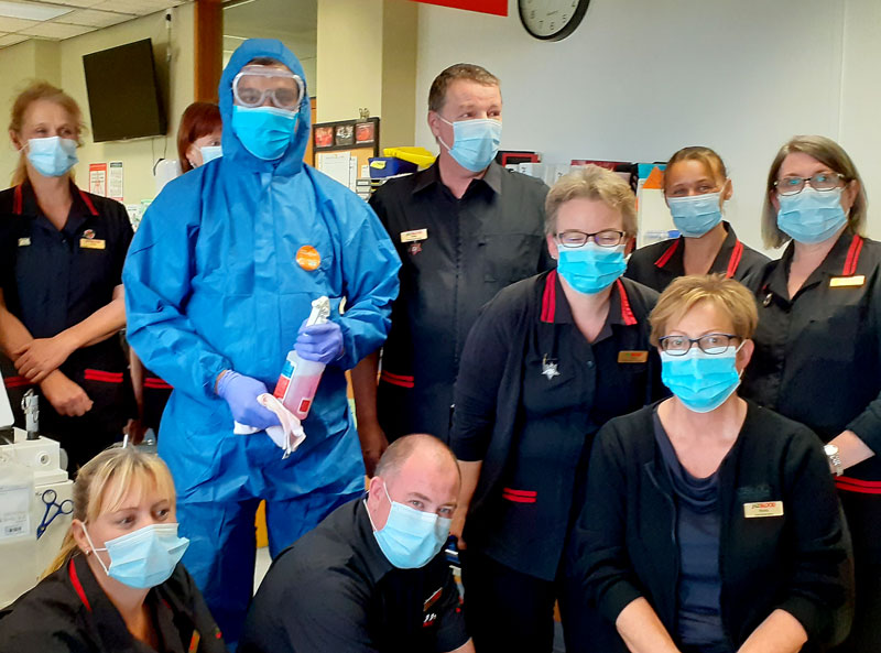 Lipson Varghese is seen in his full PPE for a photo with New Zealand Blood Service personnel at Palmerston North.
