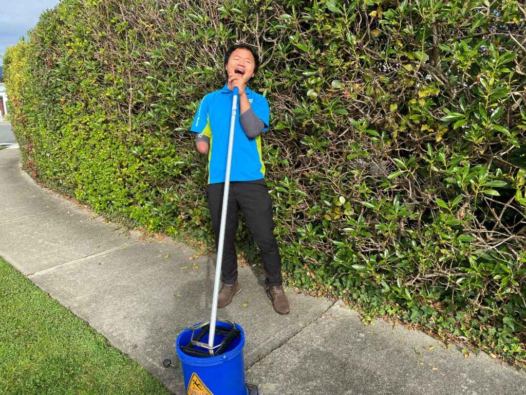 Cleaner using his mop as a microphone.