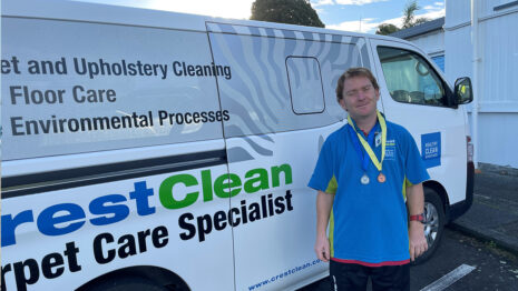 Cleaner wearing sports medals around his neck.