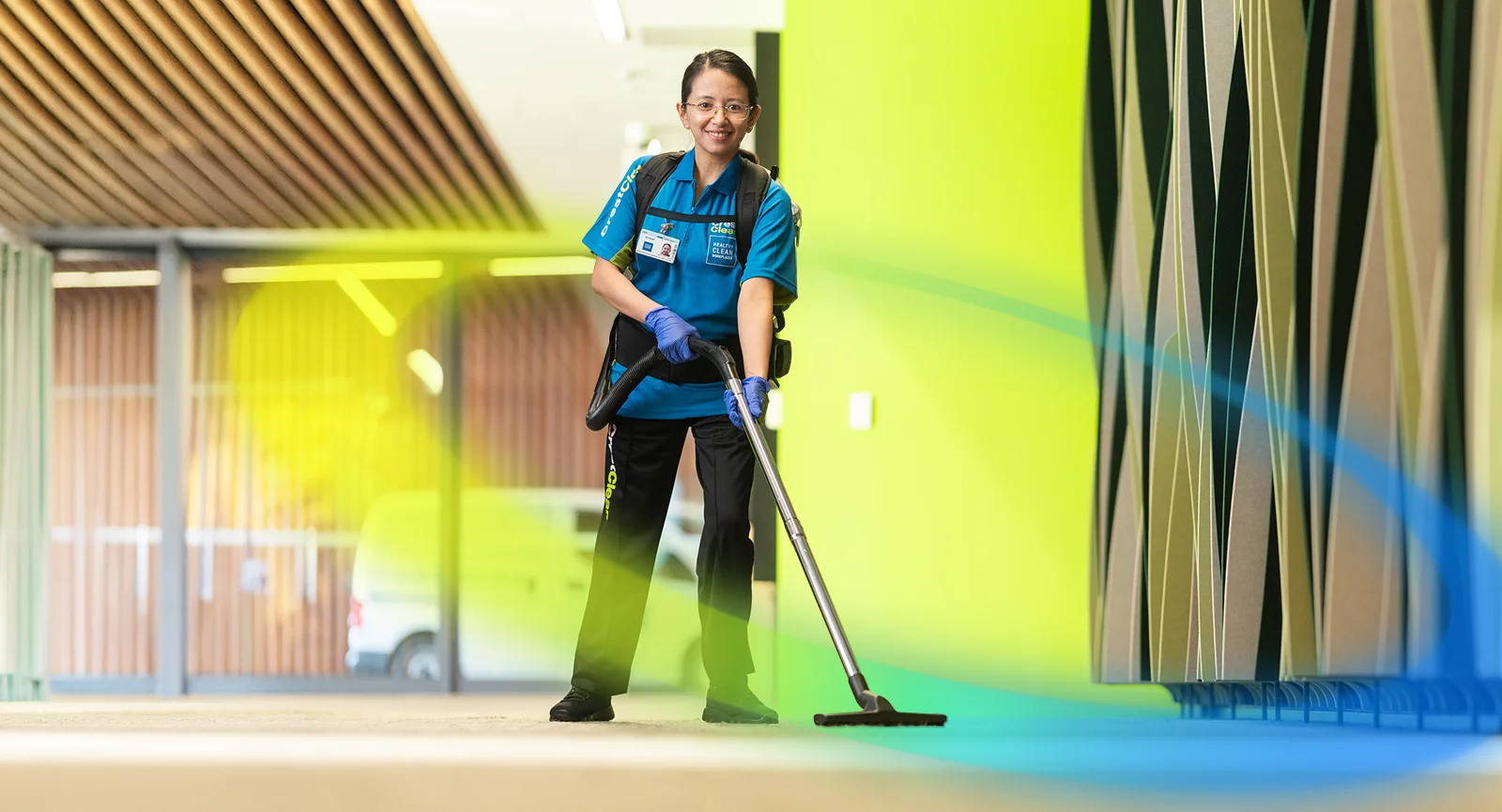 Cleaner vacuuming corporate office hallway